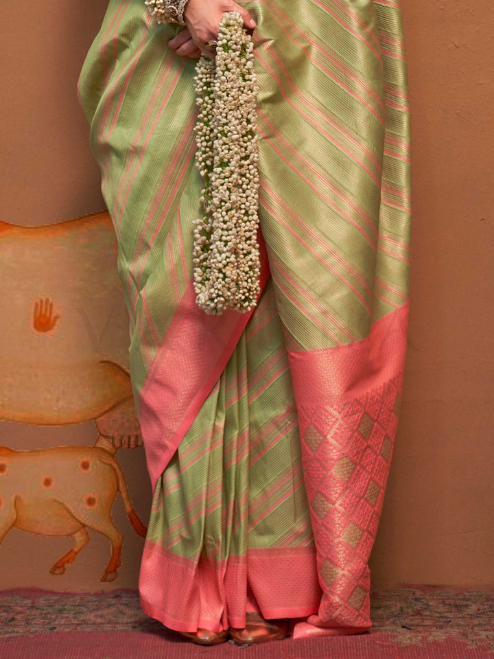 Pista Green and Peach striped silk saree with handloom weave and checked pallu. Ideal for festive season functions like ganesh chaturthi, styled with heritage jewelry and temple-inspired accessories. This image captures the back drape focus revealing pallu finesse and motif richness, ideal for visualizing festive elegance, designer appeal, and modern styling inspiration. Perfect for online shoppers seeking detailed previews before purchase, enhancing saree visual merchandising and SEO-rich product display s