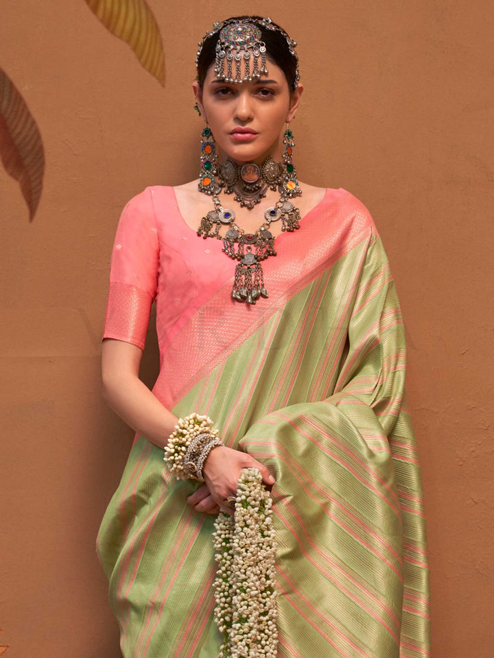 Pista Green and Peach striped silk saree with handloom weave and checked pallu. Ideal for festive season functions like ganesh chaturthi, styled with heritage jewelry and temple-inspired accessories. This image captures the side angle view showcasing blouse styling and zari border detail, ideal for visualizing festive elegance, designer appeal, and modern styling inspiration. Perfect for online shoppers seeking detailed previews before purchase, enhancing saree visual merchandising and SEO-rich product disp