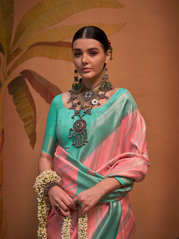 Pink and Sea Green striped silk saree with handloom weave and checked pallu. Ideal for wedding functions like reception look, styled with heritage jewelry and temple-inspired accessories. This image captures the model styling perspective with complete saree ensemble displayed, ideal for visualizing festive elegance, designer appeal, and modern styling inspiration. Perfect for online shoppers seeking detailed previews before purchase, enhancing saree visual merchandising and SEO-rich product display strategy