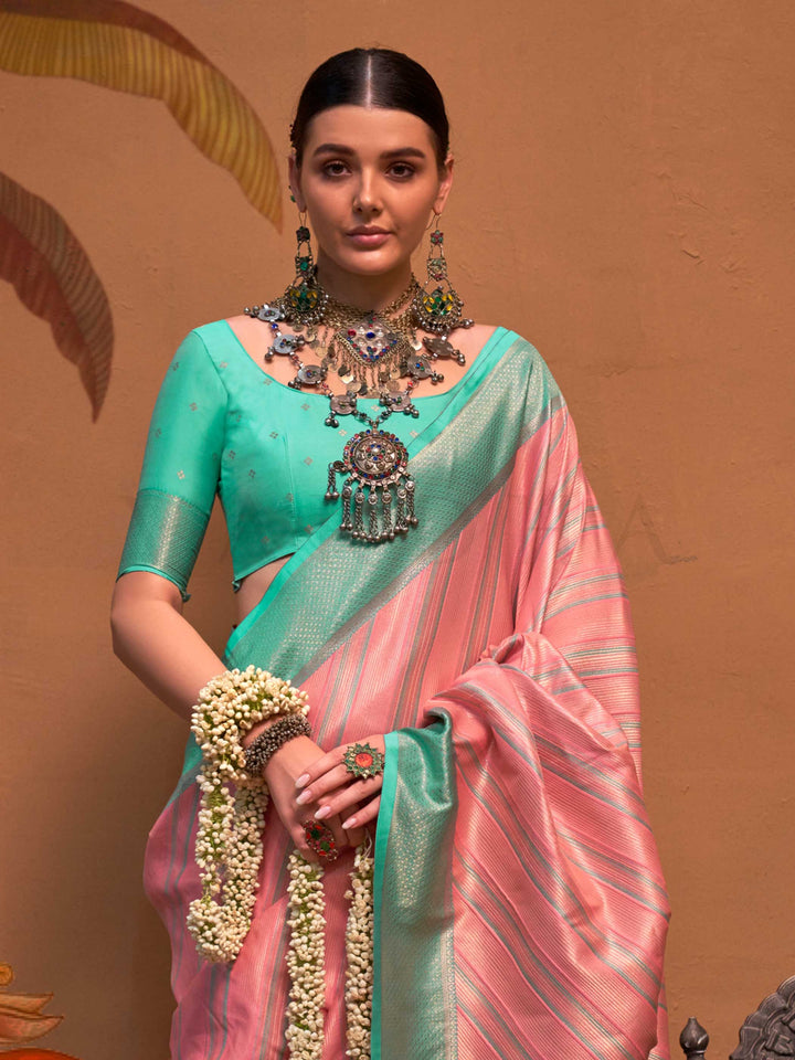 Pink and Sea Green striped silk saree with handloom weave and checked pallu. Ideal for wedding functions like reception look, styled with heritage jewelry and temple-inspired accessories. This image captures the side angle view showcasing blouse styling and zari border detail, ideal for visualizing festive elegance, designer appeal, and modern styling inspiration. Perfect for online shoppers seeking detailed previews before purchase, enhancing saree visual merchandising and SEO-rich product display strategy