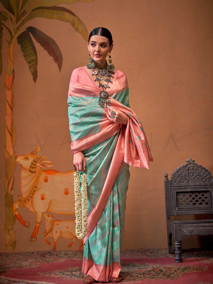 Mint Green and Blush Peach striped silk saree with handloom weave and checked pallu. Ideal for party-wear functions like cultural events, styled with heritage jewelry and temple-inspired accessories. This image captures the front drape view highlighting pallu fall and pleats alignment, ideal for visualizing festive elegance, designer appeal, and modern styling inspiration. Perfect for online shoppers seeking detailed previews before purchase, enhancing saree visual merchandising and SEO-rich product display