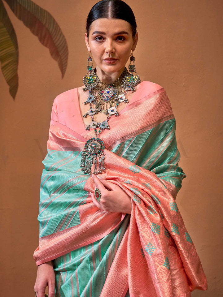 Mint Green and Blush Peach striped silk saree with handloom weave and checked pallu. Ideal for party-wear functions like cultural events, styled with heritage jewelry and temple-inspired accessories. This image captures the pleats close-up showing symmetry, color blending, and craftsmanship, ideal for visualizing festive elegance, designer appeal, and modern styling inspiration. Perfect for online shoppers seeking detailed previews before purchase, enhancing saree visual merchandising and SEO-rich product d