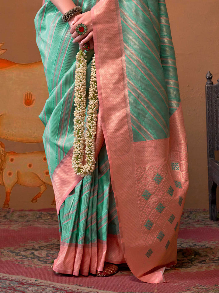 Mint Green and Blush Peach striped silk saree with handloom weave and checked pallu. Ideal for party-wear functions like cultural events, styled with heritage jewelry and temple-inspired accessories. This image captures the back drape focus revealing pallu finesse and motif richness, ideal for visualizing festive elegance, designer appeal, and modern styling inspiration. Perfect for online shoppers seeking detailed previews before purchase, enhancing saree visual merchandising and SEO-rich product display s
