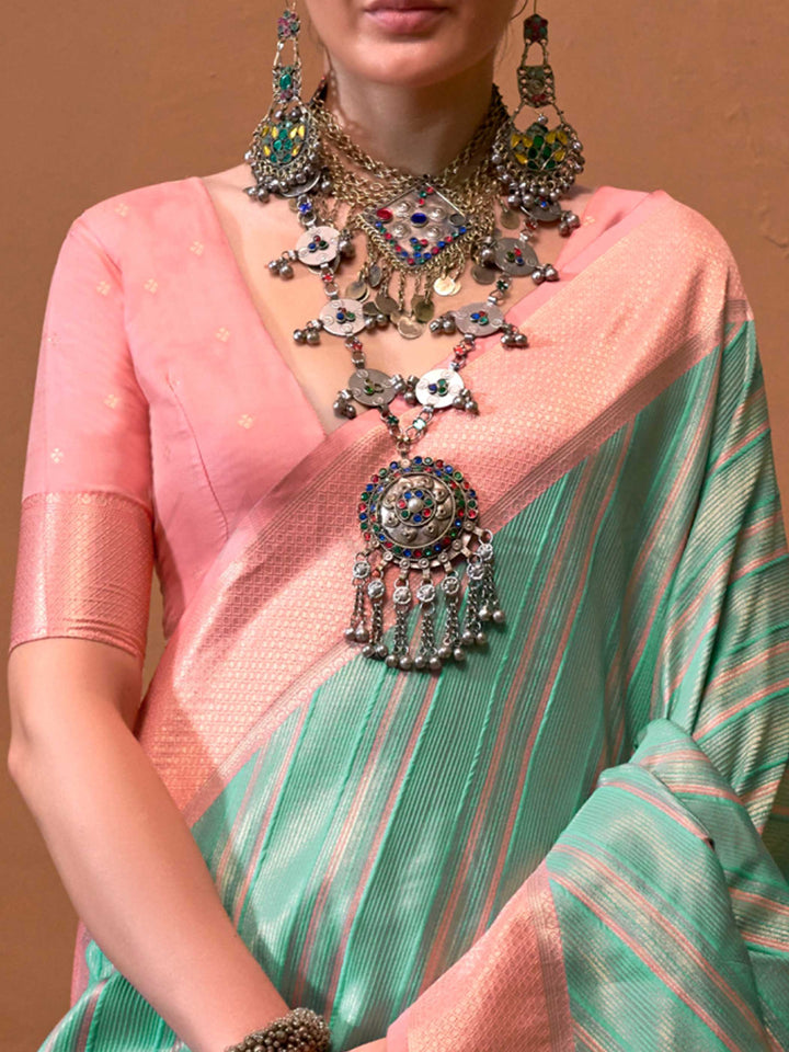 Mint Green and Blush Peach striped silk saree with handloom weave and checked pallu. Ideal for party-wear functions like cultural events, styled with heritage jewelry and temple-inspired accessories. This image captures the zoomed texture view illustrating fabric weave and print clarity, ideal for visualizing festive elegance, designer appeal, and modern styling inspiration. Perfect for online shoppers seeking detailed previews before purchase, enhancing saree visual merchandising and SEO-rich product displ