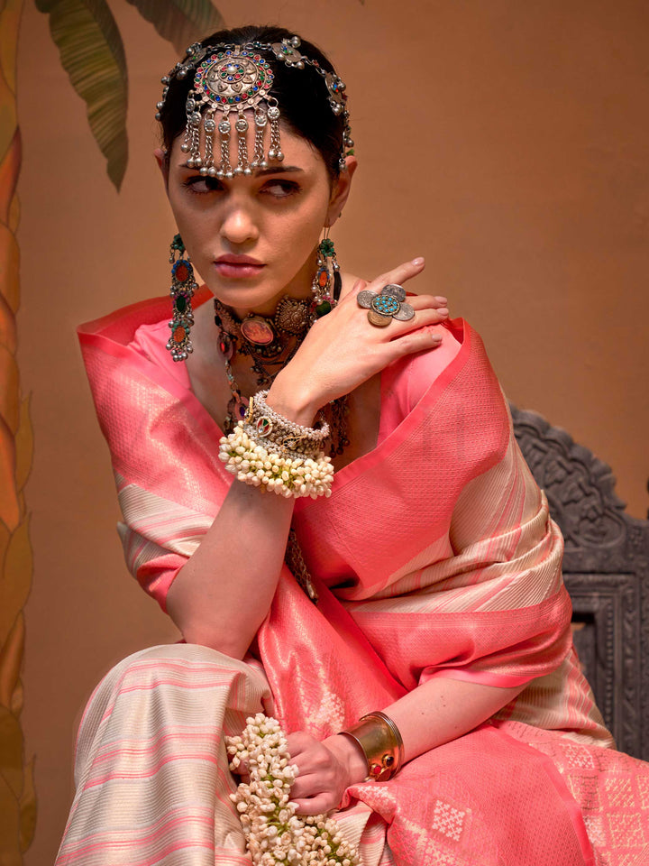 Ivory and Coral Pink striped silk saree with handloom weave and checked pallu. Ideal for wedding functions like bridal day pooja, styled with heritage jewelry and temple-inspired accessories. This image captures the model styling perspective with complete saree ensemble displayed, ideal for visualizing festive elegance, designer appeal, and modern styling inspiration. Perfect for online shoppers seeking detailed previews before purchase, enhancing saree visual merchandising and SEO-rich product display stra