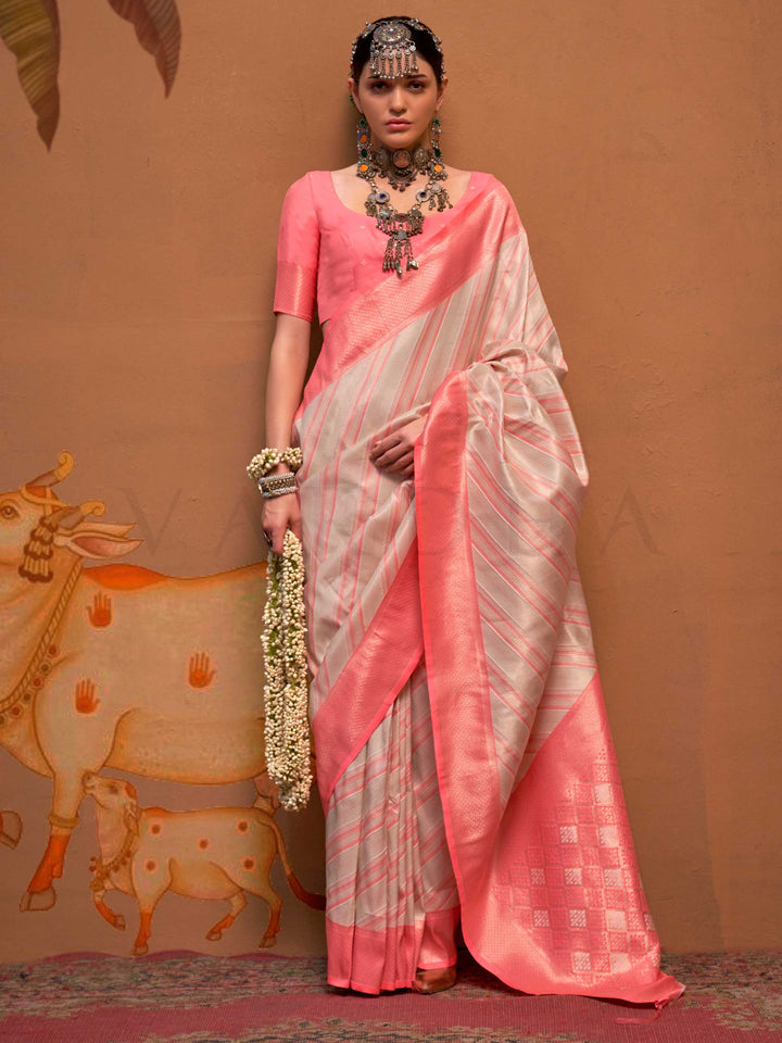 Ivory and Coral Pink striped silk saree with handloom weave and checked pallu. Ideal for wedding functions like bridal day pooja, styled with heritage jewelry and temple-inspired accessories. This image captures the front drape view highlighting pallu fall and pleats alignment, ideal for visualizing festive elegance, designer appeal, and modern styling inspiration. Perfect for online shoppers seeking detailed previews before purchase, enhancing saree visual merchandising and SEO-rich product display strateg