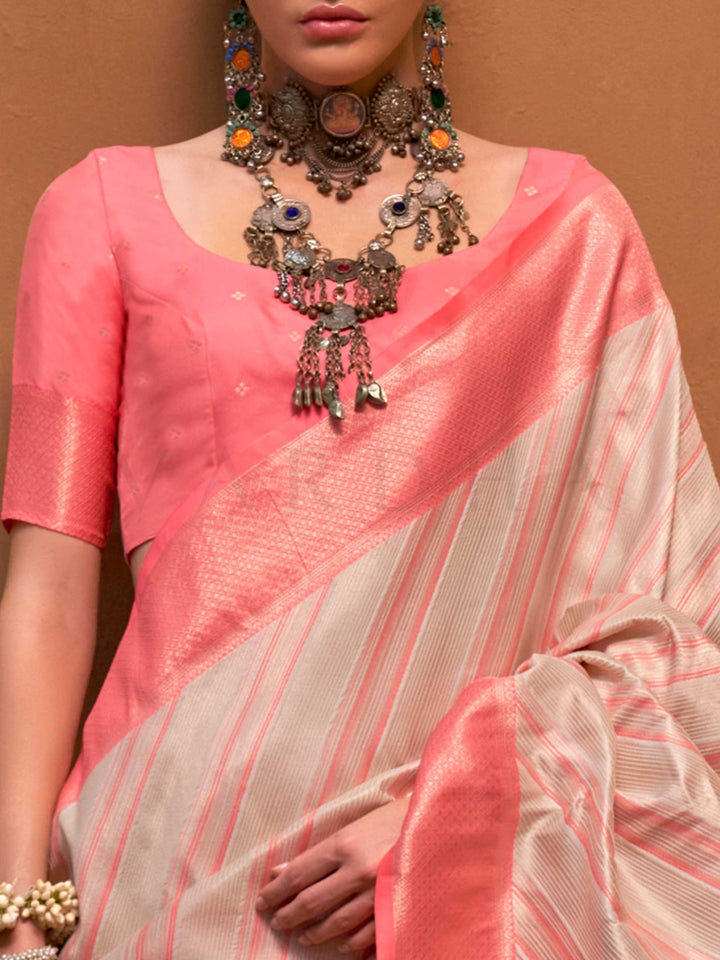 Ivory and Coral Pink striped silk saree with handloom weave and checked pallu. Ideal for wedding functions like bridal day pooja, styled with heritage jewelry and temple-inspired accessories. This image captures the zoomed texture view illustrating fabric weave and print clarity, ideal for visualizing festive elegance, designer appeal, and modern styling inspiration. Perfect for online shoppers seeking detailed previews before purchase, enhancing saree visual merchandising and SEO-rich product display strat