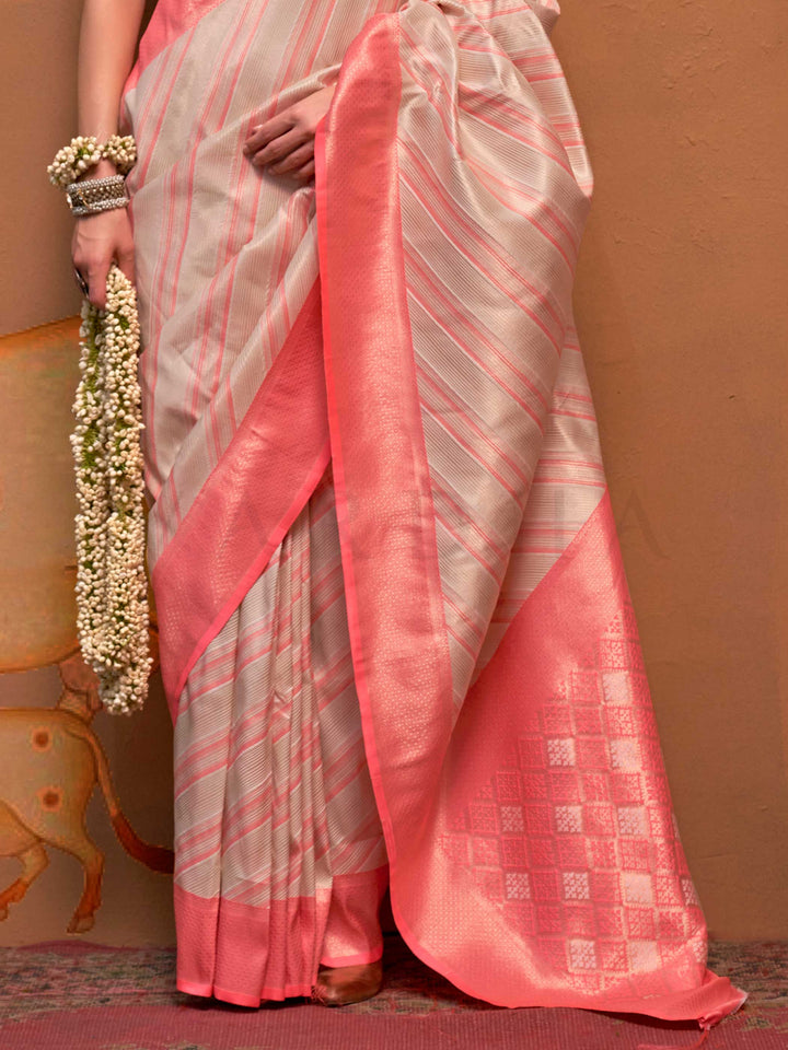 Ivory and Coral Pink striped silk saree with handloom weave and checked pallu. Ideal for wedding functions like bridal day pooja, styled with heritage jewelry and temple-inspired accessories. This image captures the back drape focus revealing pallu finesse and motif richness, ideal for visualizing festive elegance, designer appeal, and modern styling inspiration. Perfect for online shoppers seeking detailed previews before purchase, enhancing saree visual merchandising and SEO-rich product display strategy.