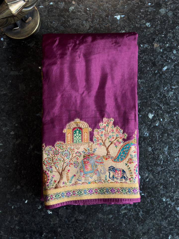 Purple fabric with intricate embroidery on a dark surface