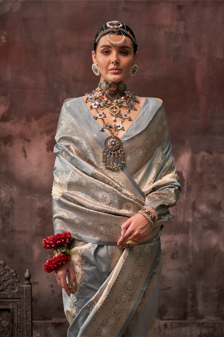 Pearl Grey and Ivory Rangkaat silk saree with temple borders, intricate zari pallu, and traditional wedding styling. Handloom drape perfect for party-wear functions and reception or gala, styled with mogra, antique jewelry, and regal stance. This image captures the model styling perspective with complete saree ensemble displayed, ideal for visualizing festive elegance, designer appeal, and modern styling inspiration. Perfect for online shoppers seeking detailed previews before purchase, enhancing saree visu