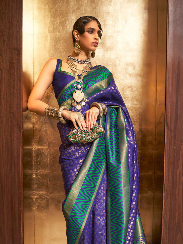 This luxurious Royal Blue–Emerald Green Kanjivaram Silk saree features classic woven zari work with contrast pallu and ornate detailing. Elegant wedding attire with heritage style and timeless drape. SKU 271004. This luxurious Royal Blue–Emerald Green Kanjivaram Silk saree features classic woven zari work with contrast pallu and ornate detailing. Elegant wedding attire with heritage style and timeless drape. SKU 271004.