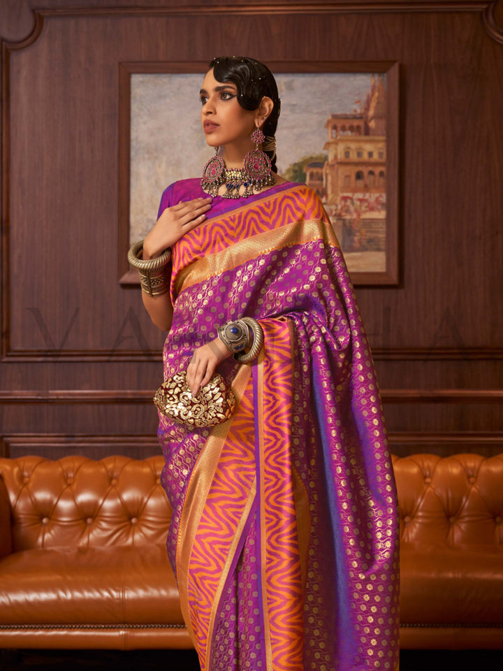 This luxurious Purple–Sunset Orange Kanjivaram Silk saree features classic woven zari work with contrast pallu and ornate detailing. Elegant wedding attire with heritage style and timeless drape. SKU 271005. This luxurious Purple–Sunset Orange Kanjivaram Silk saree features classic woven zari work with contrast pallu and ornate detailing. Elegant wedding attire with heritage style and timeless drape. SKU 271005.