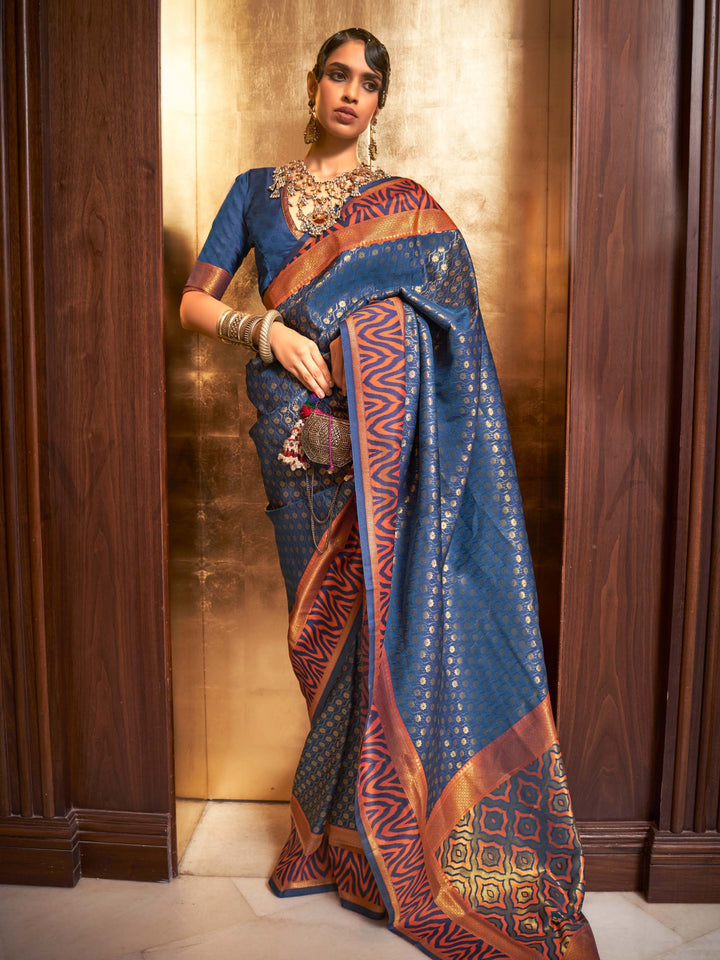 This luxurious Navy Blue–Copper Kanjivaram Silk saree features classic woven zari work with contrast pallu and ornate detailing. Elegant wedding attire with heritage style and timeless drape. SKU 271008. This luxurious Navy Blue–Copper Kanjivaram Silk saree features classic woven zari work with contrast pallu and ornate detailing. Elegant wedding attire with heritage style and timeless drape. SKU 271008.