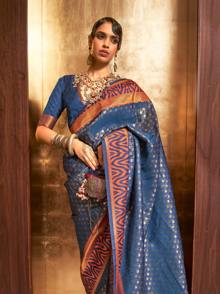 This luxurious Navy Blue–Copper Kanjivaram Silk saree features classic woven zari work with contrast pallu and ornate detailing. Elegant wedding attire with heritage style and timeless drape. SKU 271008. This luxurious Navy Blue–Copper Kanjivaram Silk saree features classic woven zari work with contrast pallu and ornate detailing. Elegant wedding attire with heritage style and timeless drape. SKU 271008.