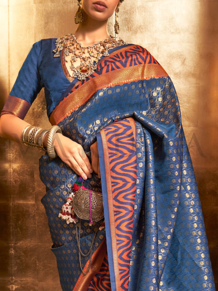 This luxurious Navy Blue–Copper Kanjivaram Silk saree features classic woven zari work with contrast pallu and ornate detailing. Elegant wedding attire with heritage style and timeless drape. SKU 271008. This luxurious Navy Blue–Copper Kanjivaram Silk saree features classic woven zari work with contrast pallu and ornate detailing. Elegant wedding attire with heritage style and timeless drape. SKU 271008.