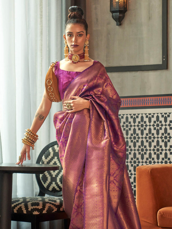 Purple–Rose Gold silk saree featuring temple borders, zari detailing and dual-tone richness. Wedding-ready kanjivaram saree in Purple–Rose Gold styled with regal accessories and clutch.