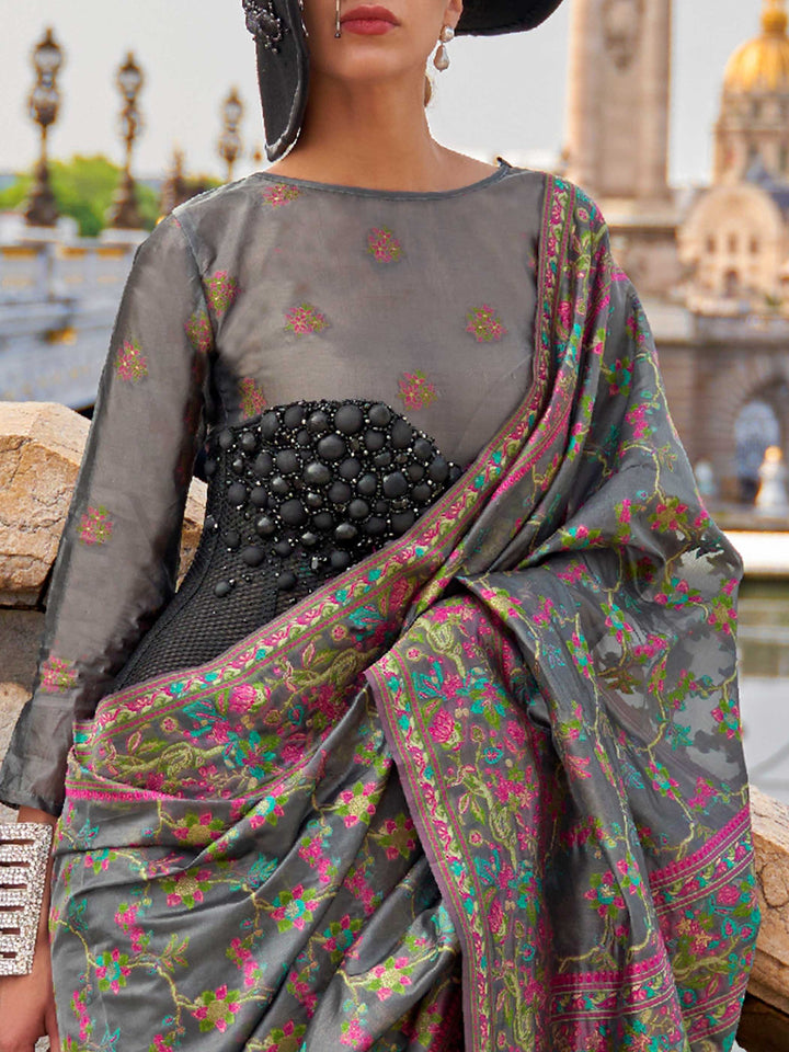 Charcoal Grey organza parsi silk saree with intricate multicolor thread floral embroidery and handloom craftsmanship, ideal for festive season and styled perfectly for diwali celebration elegance and fashion-forward flair. This image captures the zoomed texture view illustrating fabric weave and print clarity, ideal for visualizing festive elegance, designer appeal, and modern styling inspiration. Perfect for online shoppers seeking detailed previews before purchase, enhancing saree visual merchandising and