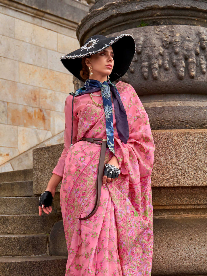 Rose Pink organza parsi silk saree with intricate multicolor thread floral embroidery and handloom craftsmanship, ideal for festive season and styled perfectly for haldi glow elegance and fashion-forward flair. This image captures the side angle view showcasing blouse styling and zari border detail, ideal for visualizing festive elegance, designer appeal, and modern styling inspiration. Perfect for online shoppers seeking detailed previews before purchase, enhancing saree visual merchandising and SEO-rich p