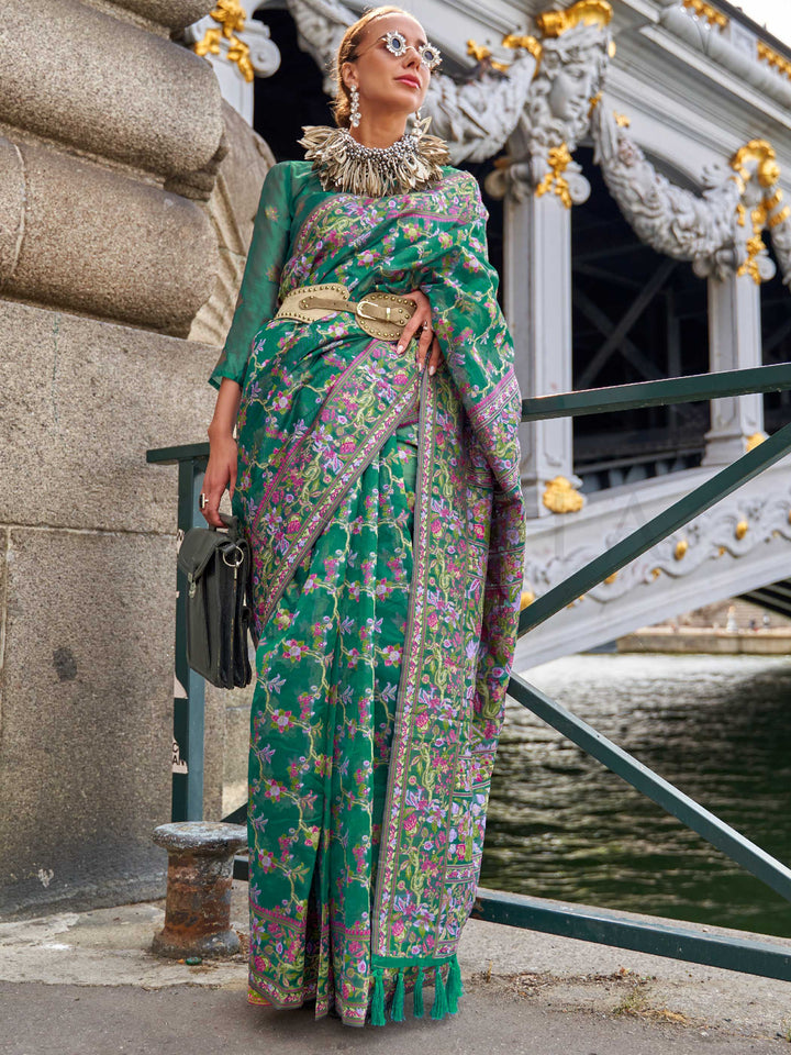 Emerald Green organza parsi silk saree with intricate multicolor thread floral embroidery and handloom craftsmanship, ideal for sangeet and styled perfectly for evening performance elegance and fashion-forward flair. This image captures the front drape view highlighting pallu fall and pleats alignment, ideal for visualizing festive elegance, designer appeal, and modern styling inspiration. Perfect for online shoppers seeking detailed previews before purchase, enhancing saree visual merchandising and SEO-ric