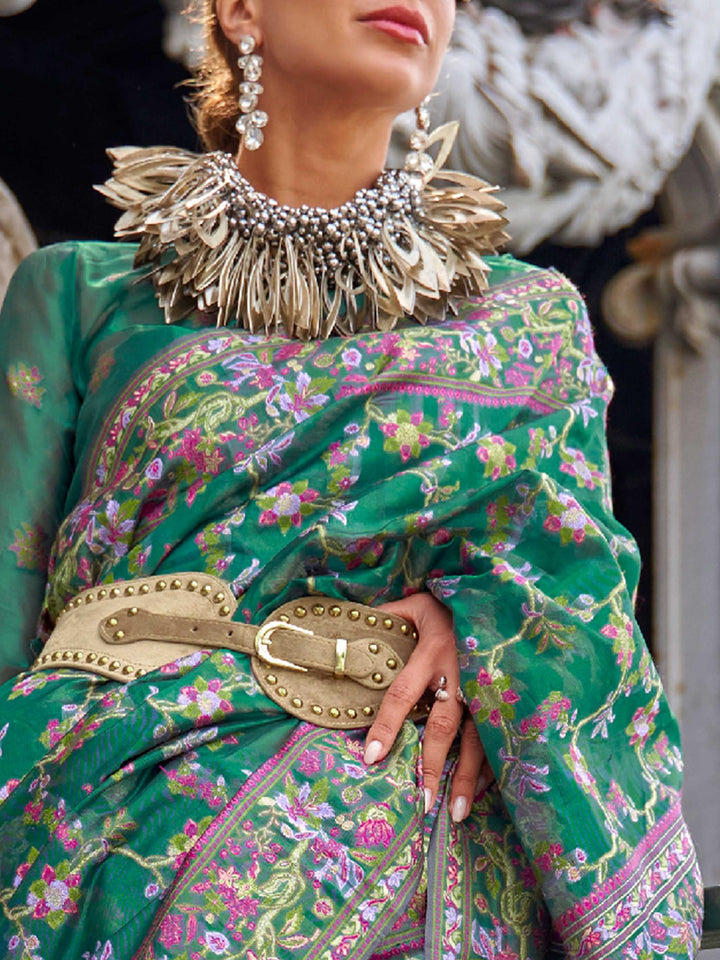 Emerald Green organza parsi silk saree with intricate multicolor thread floral embroidery and handloom craftsmanship, ideal for sangeet and styled perfectly for evening performance elegance and fashion-forward flair. This image captures the zoomed texture view illustrating fabric weave and print clarity, ideal for visualizing festive elegance, designer appeal, and modern styling inspiration. Perfect for online shoppers seeking detailed previews before purchase, enhancing saree visual merchandising and SEO-r