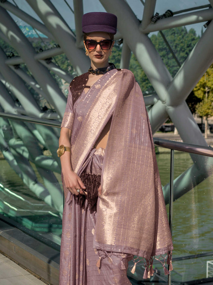 Dusty Lilac Katan silk saree with Rose Gold zari detailing, featuring checks handloom weaving, designer blouse and tasselled pallu — a perfect fit for party-wear and fashion walk. Styled with modern belts, hats, and accessories to blend heritage and couture elegance. This image captures the side angle view showcasing blouse styling and zari border detail, ideal for visualizing festive elegance, designer appeal, and modern styling inspiration. Perfect for online shoppers seeking detailed previews before purc