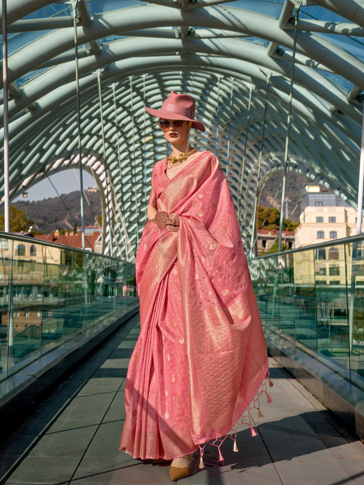Coral Peach Katan silk saree with Gold zari detailing, featuring checks handloom weaving, designer blouse and tasselled pallu — a perfect fit for wedding and reception night. Styled with modern belts, hats, and accessories to blend heritage and couture elegance. This image captures the front drape view highlighting pallu fall and pleats alignment, ideal for visualizing festive elegance, designer appeal, and modern styling inspiration. Perfect for online shoppers seeking detailed previews before purchase, en