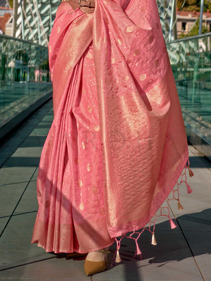 Coral Peach Katan silk saree with Gold zari detailing, featuring checks handloom weaving, designer blouse and tasselled pallu — a perfect fit for wedding and reception night. Styled with modern belts, hats, and accessories to blend heritage and couture elegance. This image captures the back drape focus revealing pallu finesse and motif richness, ideal for visualizing festive elegance, designer appeal, and modern styling inspiration. Perfect for online shoppers seeking detailed previews before purchase, enha