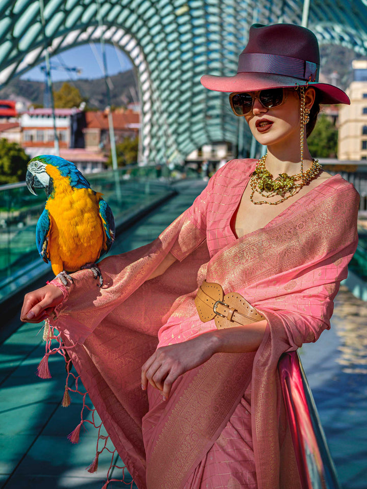 Coral Peach Katan silk saree with Gold zari detailing, featuring checks handloom weaving, designer blouse and tasselled pallu — a perfect fit for wedding and reception night. Styled with modern belts, hats, and accessories to blend heritage and couture elegance. This image captures the model styling perspective with complete saree ensemble displayed, ideal for visualizing festive elegance, designer appeal, and modern styling inspiration. Perfect for online shoppers seeking detailed previews before purchase,