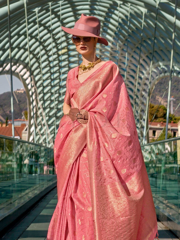 Coral Peach Katan silk saree with Gold zari detailing, featuring checks handloom weaving, designer blouse and tasselled pallu — a perfect fit for wedding and reception night. Styled with modern belts, hats, and accessories to blend heritage and couture elegance. This image captures the side angle view showcasing blouse styling and zari border detail, ideal for visualizing festive elegance, designer appeal, and modern styling inspiration. Perfect for online shoppers seeking detailed previews before purchase,