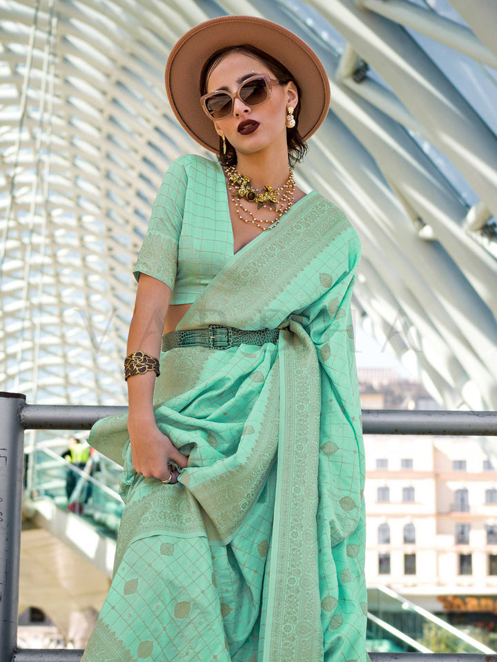 Mint Green Katan silk saree with Beige Gold zari detailing, featuring checks handloom weaving, designer blouse and tasselled pallu — a perfect fit for festive season and haldi ceremony. Styled with modern belts, hats, and accessories to blend heritage and couture elegance. This image captures the side angle view showcasing blouse styling and zari border detail, ideal for visualizing festive elegance, designer appeal, and modern styling inspiration. Perfect for online shoppers seeking detailed previews befor
