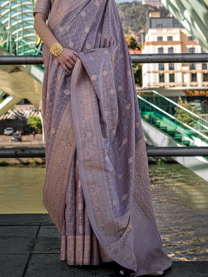 Grey Mauve Katan silk saree with Beige Gold zari detailing, featuring checks handloom weaving, designer blouse and tasselled pallu — a perfect fit for wedding and engagement function. Styled with modern belts, hats, and accessories to blend heritage and couture elegance. This image captures the back drape focus revealing pallu finesse and motif richness, ideal for visualizing festive elegance, designer appeal, and modern styling inspiration. Perfect for online shoppers seeking detailed previews before purch