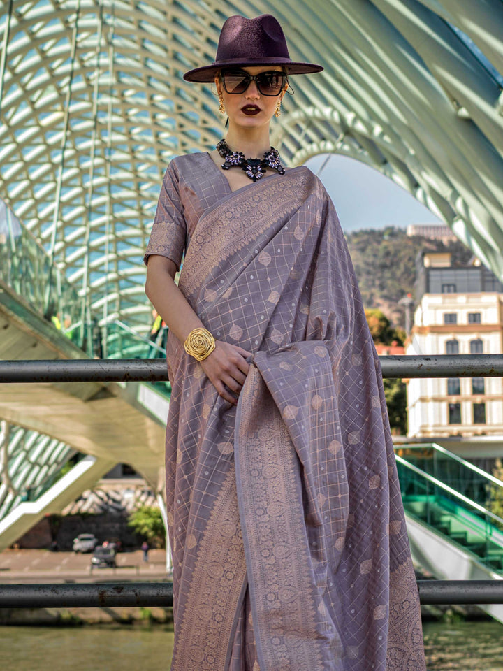 Grey Mauve Katan silk saree with Beige Gold zari detailing, featuring checks handloom weaving, designer blouse and tasselled pallu — a perfect fit for wedding and engagement function. Styled with modern belts, hats, and accessories to blend heritage and couture elegance. This image captures the side angle view showcasing blouse styling and zari border detail, ideal for visualizing festive elegance, designer appeal, and modern styling inspiration. Perfect for online shoppers seeking detailed previews before