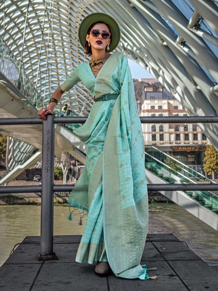 Seafoam Green Katan silk saree with Cool Beige zari detailing, featuring checks handloom weaving, designer blouse and tasselled pallu — a perfect fit for festive season and day pooja & diwali. Styled with modern belts, hats, and accessories to blend heritage and couture elegance. This image captures the front drape view highlighting pallu fall and pleats alignment, ideal for visualizing festive elegance, designer appeal, and modern styling inspiration. Perfect for online shoppers seeking detailed previews b