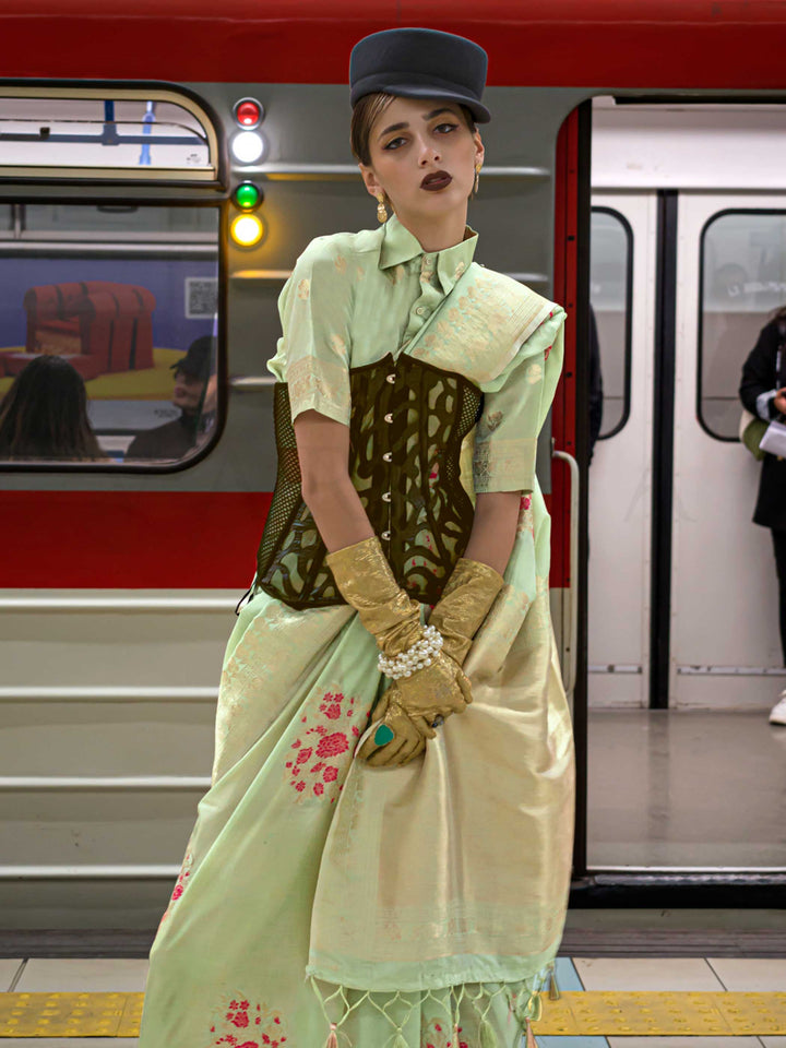 Mint Green silk saree with Beige Zari zari and Peach Blossom floral motifs, styled with contrast blouse, handloom weaving, festive-ready look with cinematic silhouette and bold accessories — ideal for events and grand celebrations. This image captures the side angle view showcasing blouse styling and zari border detail, ideal for visualizing festive elegance, designer appeal, and modern styling inspiration. Perfect for online shoppers seeking detailed previews before purchase, enhancing saree visual merchan