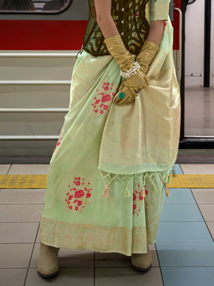 Mint Green silk saree with Beige Zari zari and Peach Blossom floral motifs, styled with contrast blouse, handloom weaving, festive-ready look with cinematic silhouette and bold accessories — ideal for events and grand celebrations. This image captures the back drape focus revealing pallu finesse and motif richness, ideal for visualizing festive elegance, designer appeal, and modern styling inspiration. Perfect for online shoppers seeking detailed previews before purchase, enhancing saree visual merchandisin