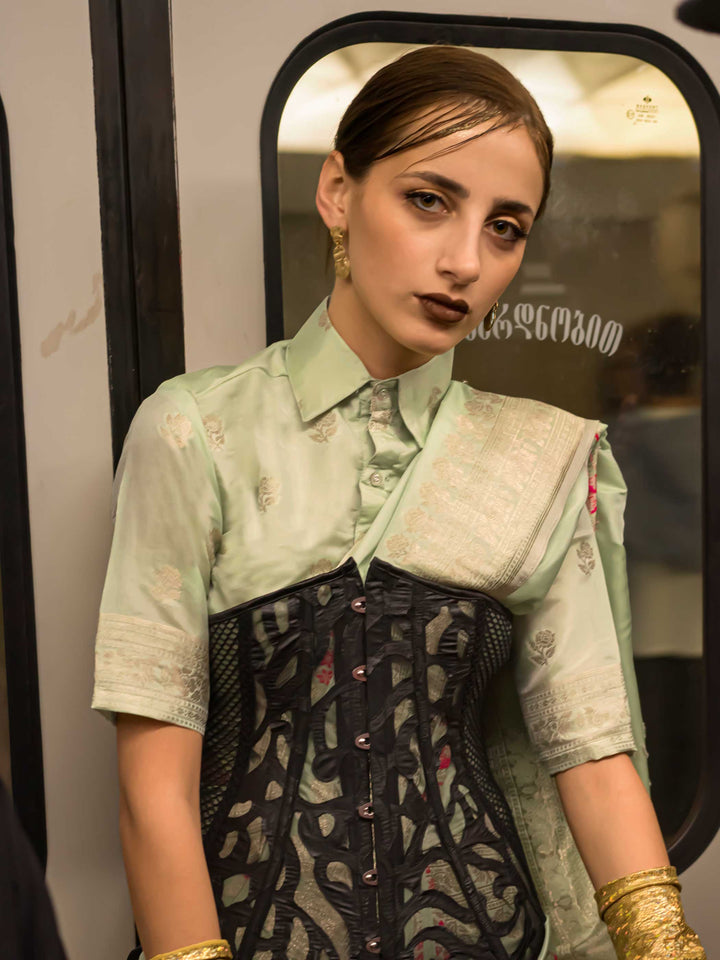 Mint Green silk saree with Beige Zari zari and Peach Blossom floral motifs, styled with contrast blouse, handloom weaving, festive-ready look with cinematic silhouette and bold accessories — ideal for events and grand celebrations. This image captures the model styling perspective with complete saree ensemble displayed, ideal for visualizing festive elegance, designer appeal, and modern styling inspiration. Perfect for online shoppers seeking detailed previews before purchase, enhancing saree visual merchan