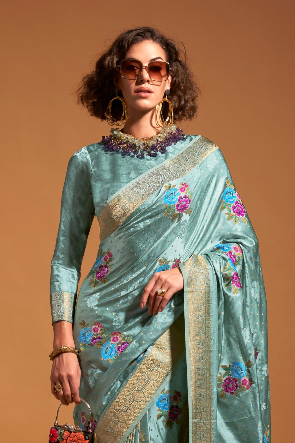 Mint Blue pure satin silk saree with multicolour floral handloom weaving and rich zari border. Styled for festive season and perfect for raksha bandhan, blending regal silk elegance with festive florals. This image captures the front drape view highlighting pallu fall and pleats alignment, ideal for visualizing festive elegance, designer appeal, and modern styling inspiration. Perfect for online shoppers seeking detailed previews before purchase, enhancing saree visual merchandising and SEO-rich product dis