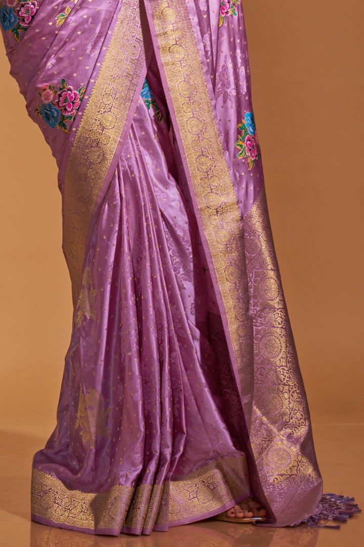 Lavender pure satin silk saree with multicolour floral handloom weaving and rich zari border. Styled for party-wear and perfect for bridal brunch, blending regal silk elegance with festive florals. This image captures the side angle view showcasing blouse styling and zari border detail, ideal for visualizing festive elegance, designer appeal, and modern styling inspiration. Perfect for online shoppers seeking detailed previews before purchase, enhancing saree visual merchandising and SEO-rich product displa