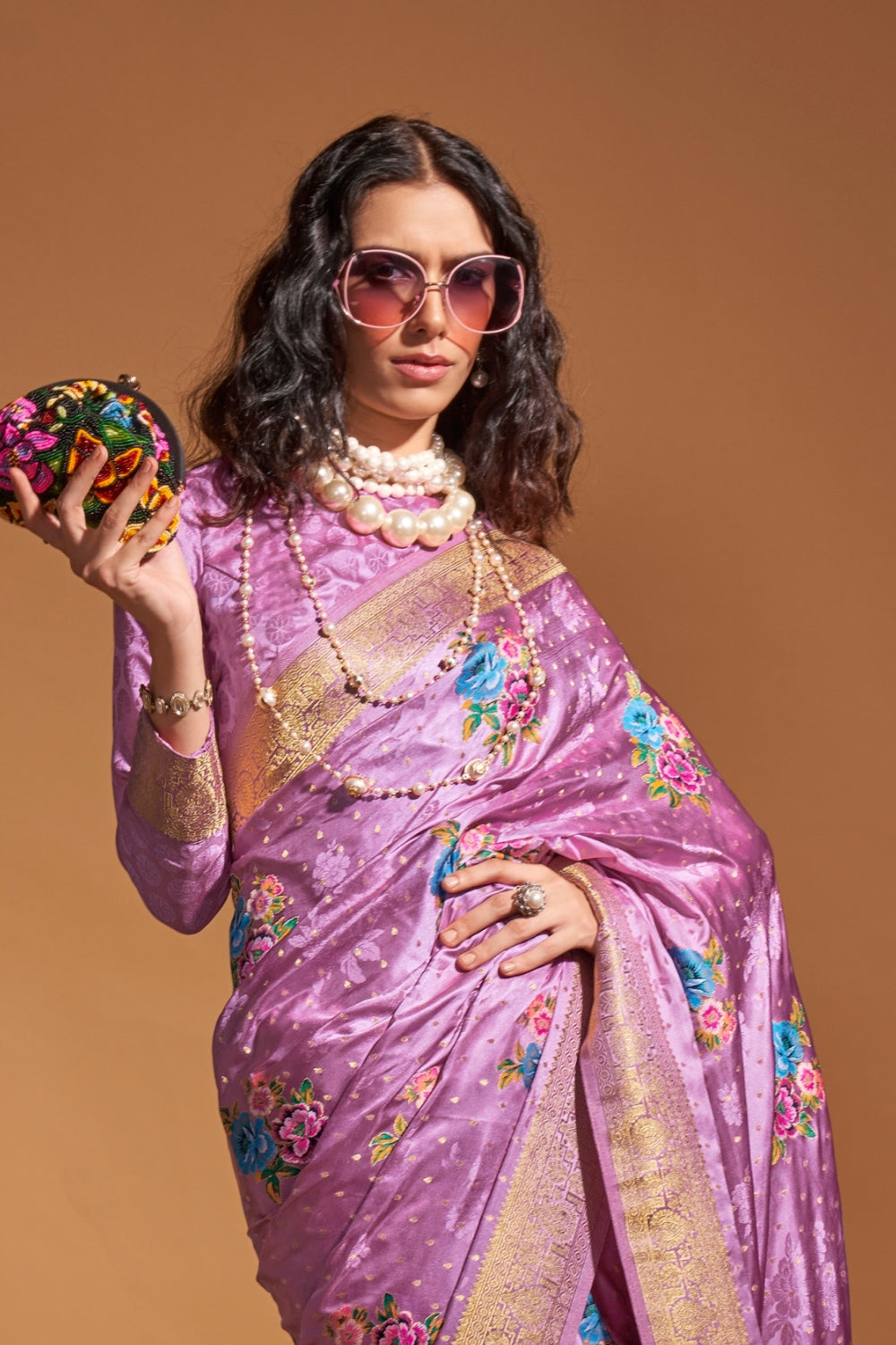 Lavender pure satin silk saree with multicolour floral handloom weaving and rich zari border. Styled for party-wear and perfect for bridal brunch, blending regal silk elegance with festive florals. This image captures the front drape view highlighting pallu fall and pleats alignment, ideal for visualizing festive elegance, designer appeal, and modern styling inspiration. Perfect for online shoppers seeking detailed previews before purchase, enhancing saree visual merchandising and SEO-rich product display s