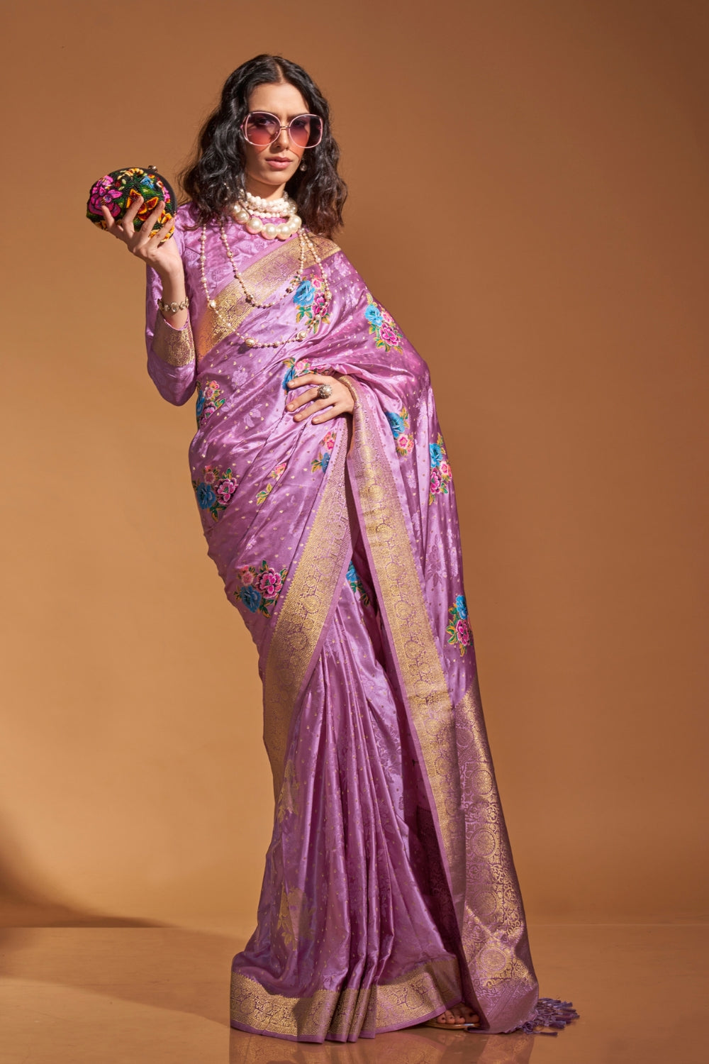 Lavender pure satin silk saree with multicolour floral handloom weaving and rich zari border. Styled for party-wear and perfect for bridal brunch, blending regal silk elegance with festive florals. This image captures the zoomed texture view illustrating fabric weave and print clarity, ideal for visualizing festive elegance, designer appeal, and modern styling inspiration. Perfect for online shoppers seeking detailed previews before purchase, enhancing saree visual merchandising and SEO-rich product display