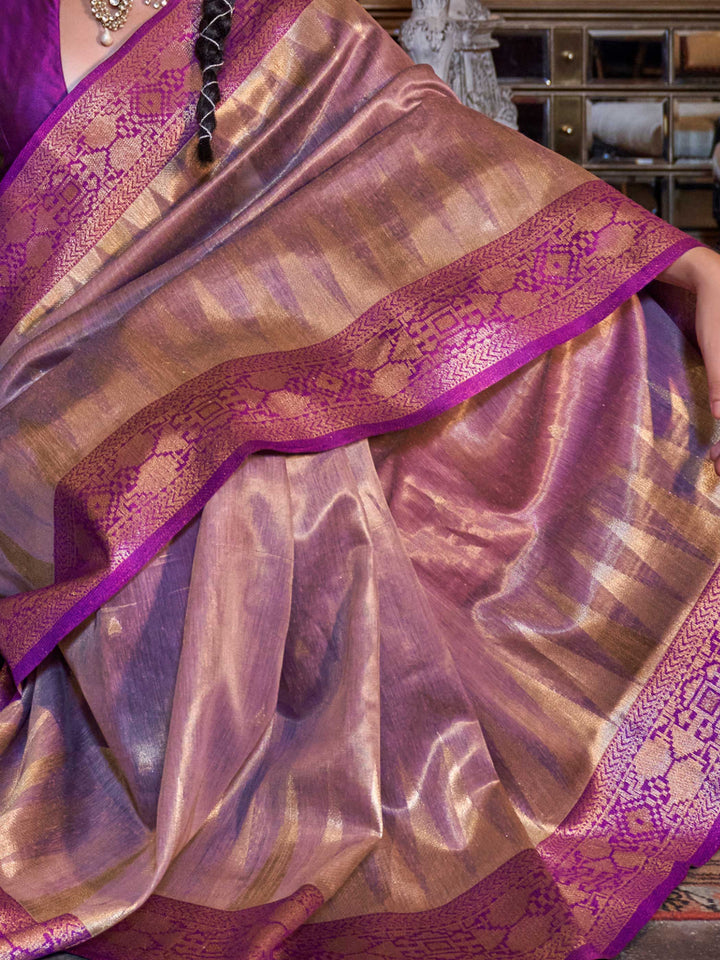 Contrast blouse and bold pleats enhance the royal charm of Golden Olive–Crimson Red ikat tissue banarasi saree. Model draped in Golden Olive–Crimson Red banarasi saree showcasing ikat pallu and heavy tissue silk weave.