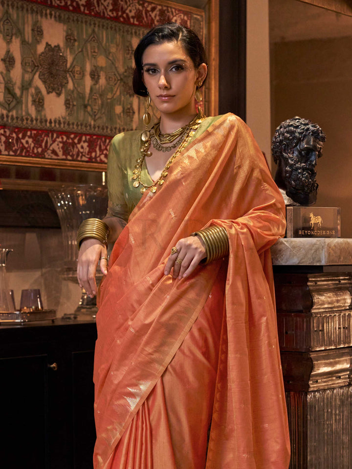 Peach Orange–Leaf Green feathersoft raw silk saree featuring banarasi ikat design, ideal for sangeet night and festive evening wear with rich texture and contrast blouse. Peach Orange–Leaf Green feathersoft raw silk saree featuring banarasi ikat design, ideal for sangeet night and festive evening wear with rich texture and contrast blouse..