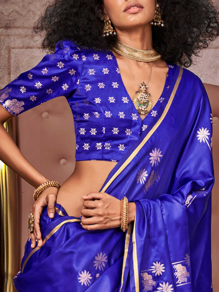 Royal Blue–Silver satin silk saree with jacquard woven motifs and floral zari detailing. Perfect partywear or reception look with embroidered blouse and traditional drape, ideal for festive fashion styling. Royal Blue–Silver satin silk saree with jacquard woven motifs and floral zari detailing. Perfect partywear or reception look with embroidered blouse and traditional drape, ideal for festive fashion styling..