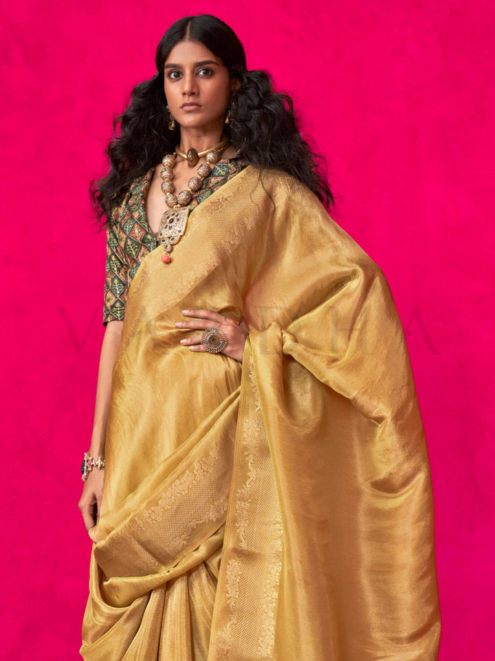 Golden Mustard–Gold Zari tissue viscose silk saree with jacquard woven zari work, ideal for weddings, bridesmaids, and elegant evening events. Features tassel border and shimmering finish. Golden Mustard–Gold Zari tissue viscose silk saree with jacquard woven zari work, ideal for weddings, bridesmaids, and elegant evening events. Features tassel border and shimmering finish..