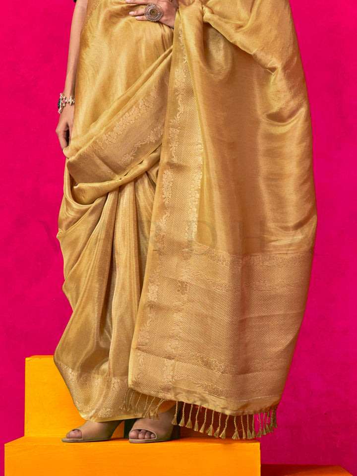 Golden Mustard–Gold Zari tissue viscose silk saree with jacquard woven zari work, ideal for weddings, bridesmaids, and elegant evening events. Features tassel border and shimmering finish. Golden Mustard–Gold Zari tissue viscose silk saree with jacquard woven zari work, ideal for weddings, bridesmaids, and elegant evening events. Features tassel border and shimmering finish..