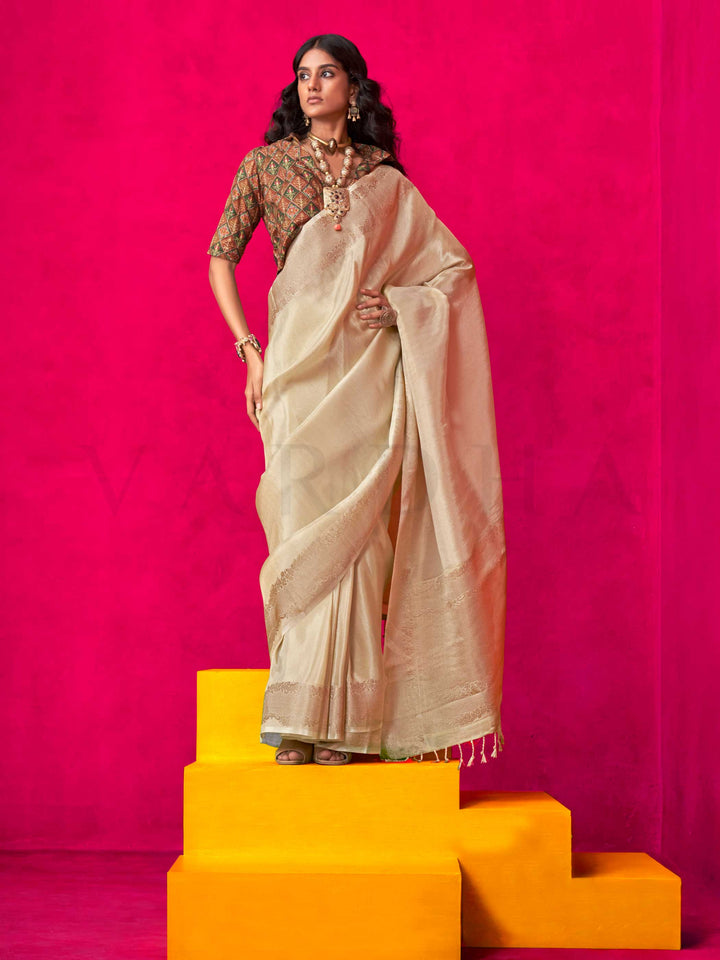Ivory Beige–Ivory Zari tissue viscose silk saree with jacquard woven zari work, ideal for weddings, bridesmaids, and elegant evening events. Features tassel border and shimmering finish. Ivory Beige–Ivory Zari tissue viscose silk saree with jacquard woven zari work, ideal for weddings, bridesmaids, and elegant evening events. Features tassel border and shimmering finish..