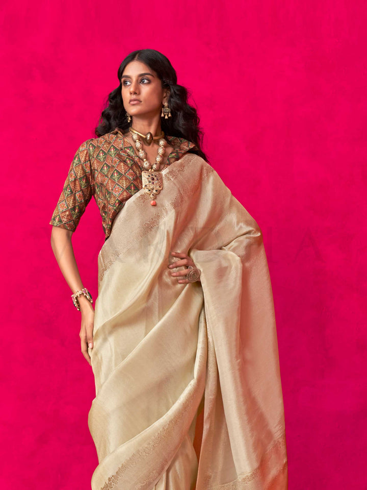 Ivory Beige–Ivory Zari tissue viscose silk saree with jacquard woven zari work, ideal for weddings, bridesmaids, and elegant evening events. Features tassel border and shimmering finish. Ivory Beige–Ivory Zari tissue viscose silk saree with jacquard woven zari work, ideal for weddings, bridesmaids, and elegant evening events. Features tassel border and shimmering finish..