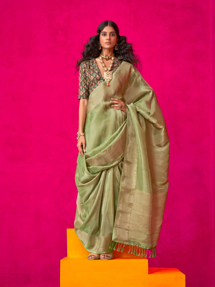 Sage Green–Olive Zari tissue viscose silk saree with jacquard woven zari work, ideal for weddings, bridesmaids, and elegant evening events. Features tassel border and shimmering finish. Sage Green–Olive Zari tissue viscose silk saree with jacquard woven zari work, ideal for weddings, bridesmaids, and elegant evening events. Features tassel border and shimmering finish..
