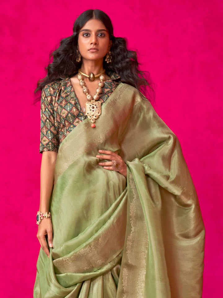 Sage Green–Olive Zari tissue viscose silk saree with jacquard woven zari work, ideal for weddings, bridesmaids, and elegant evening events. Features tassel border and shimmering finish. Sage Green–Olive Zari tissue viscose silk saree with jacquard woven zari work, ideal for weddings, bridesmaids, and elegant evening events. Features tassel border and shimmering finish..