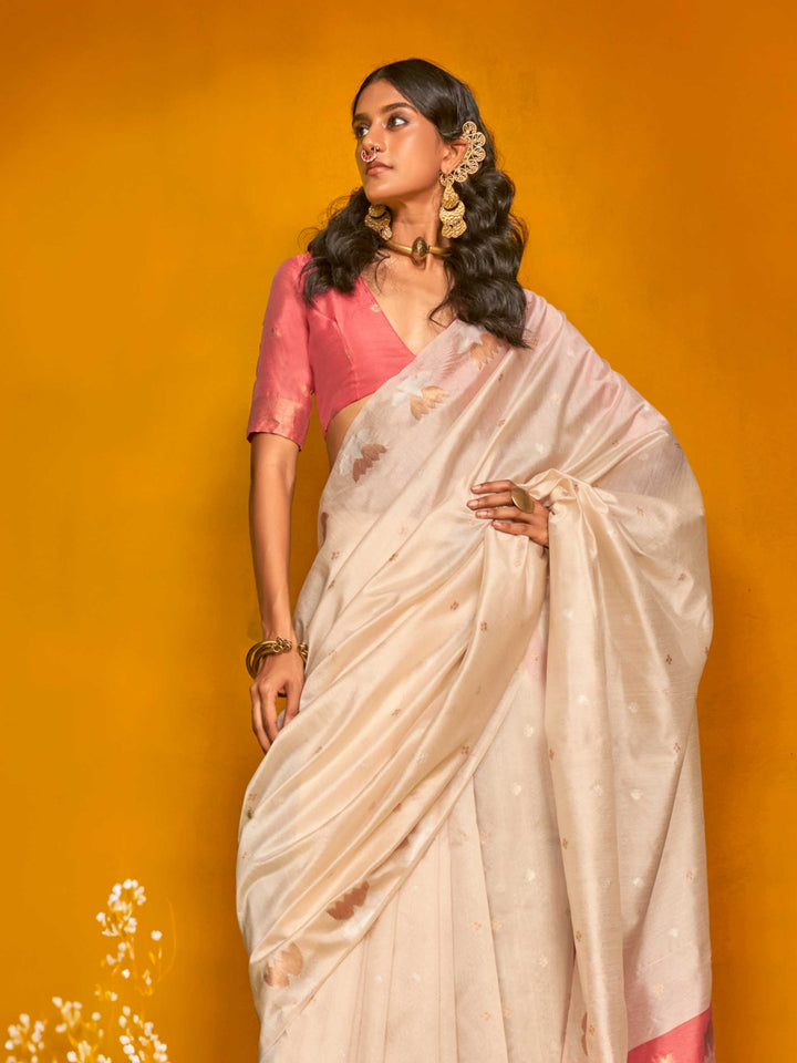 Ivory Cream–Peach Pink feathersoft tussar silk saree featuring woven lotus motifs and soft pallu, styled for festive rituals with a breathable finish. Ivory Cream–Peach Pink feathersoft tussar silk saree featuring woven lotus motifs and soft pallu, styled for festive rituals with a breathable finish..